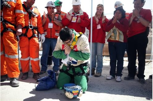 Kumpel Esteban Rojas, 44, sinkt auf die Knie um zu beten. Er wurde aus der Mine San Jose gerettet. Er war der 18., der wieder nach oben kam. Das Fernsehen...