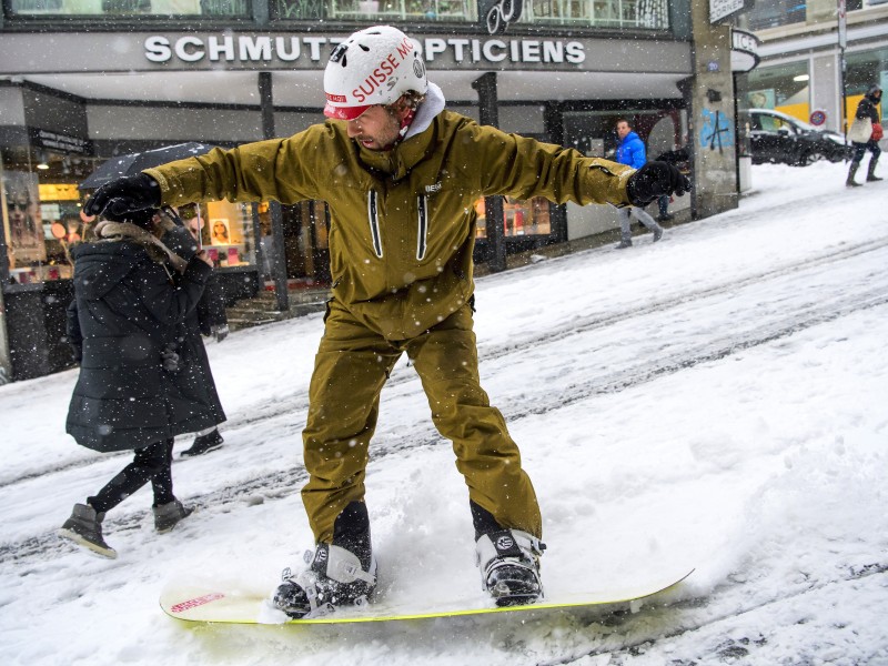 Am meteorologischen Frühlingsanfang ist fast alles möglich: Snowboard unter die Füße geschnallt und ab geht es über die mit Schnee bedeckte Straße „Rue du Petit Chene im schweizerischen Lausanne. Bilder, die mehr nach Winter als nach Frühling aussehen. 