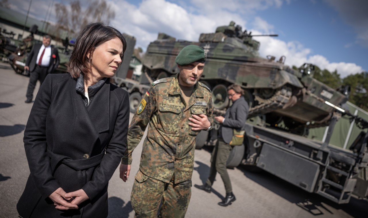 Annalena Baerbock geht bei einem Truppenbesuch in Litauen an einem Marder-Schützenpanzer vorbei. 