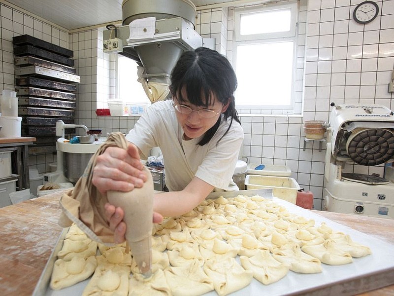 Die Baeckerei und Konditorei Auffenberg in Ickern in Castrop-Rauxel gehoert am Mittwoch, 11. April 2012, zu den wenigen Betrieben mit Brot und Broetchen aus eigener Herstellung. Gesellin Tomomi Saito stellt Plunderteilchen her. Foto: Thomas Goedde / WAZ FotoPool