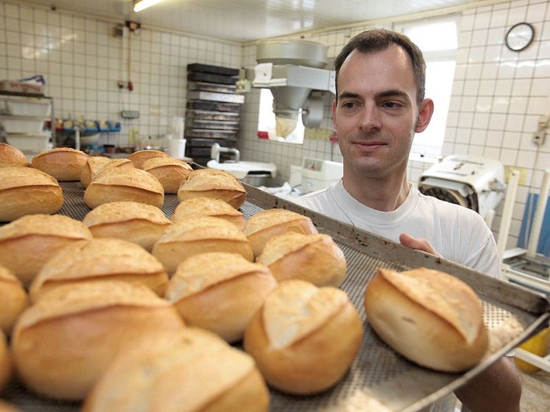 Die Baeckerei und Konditorei Auffenberg in Ickern in Castrop-Rauxel gehoert am Mittwoch, 11. April 2012, zu den wenigen Betrieben mit Brot und Broetchen aus eigener Herstellung. Immer frisch in die Tuete: Baeckermeister Alexander Auffenberg mit einem Blech Broetchen in der Backstube. Foto: Thomas Goedde / WAZ FotoPool