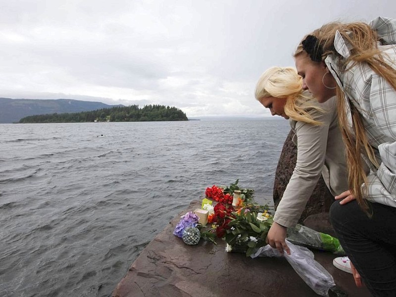 Angehörige legen Blumen nieder und trauern bei Utöya.