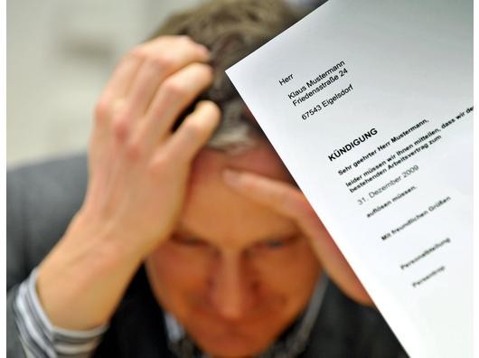 Ein Mann sitzt auf diesem gestellten Foto verzweifelt am Tisch. Vor ihm ein Kündigungsschreiben seiner Firma. Foto: Dirk Bauer / WAZ FotoPool