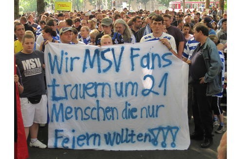 Rund 1000 Fußballfans demonstrieren Geschlossenheit bei einem Trauermarsch von der Unglücksstelle zum Duisburger Stadion - in Gedenken an die Opfer der Loveparade. Die Gewerkschaft Verdi fordert OB Adolf Sauerland auf, ...