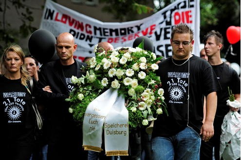 Viele Menschen ziehen bei einem Trauermarsch durch Duisburg.