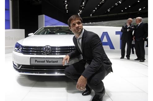 Der Wolfsburger Spieler Diego Ribas da Cunha spendet eine sportliche Pose vor einem Passat Variant-Modell.