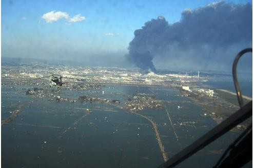 Militärhubschrauber liefern den Menschen in der überfluteten Region Sendai Lebensmittel, die Familien aus der Nachbarstadt gespendet haben. Das Straßennetz ist verwüstet.