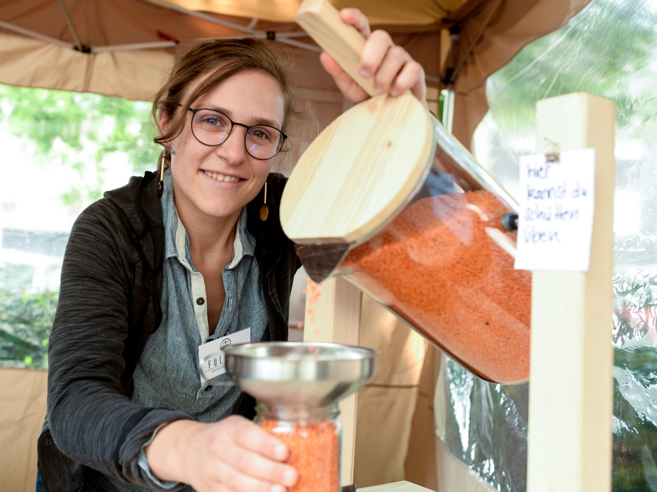 Hinter der Füllbar stehen mehrere junge Menschen, die das Lädchen zusammen eröffnet haben. 