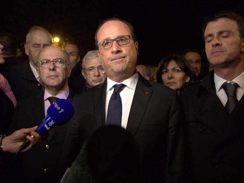 Frankreichs Präsident François Hollande (M.), Ministerpräsident Manuel Valls (r.) und Innenminister Bernard Cazeneuve (l.) sprechen am späten Freitagabend vor der Konzerthalle Bataclan mit den Medien. Hollande verhängt den Ausnahmezustand.