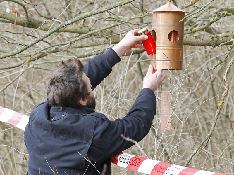 Ein Betroffener hängt an der Unglücksstelle eine Kerze in einen  Baum. 