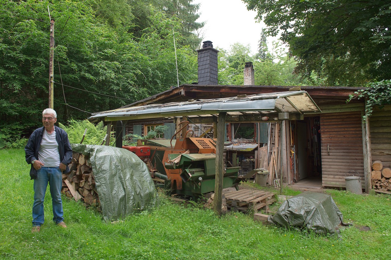 Der Einsiedler Günther Hamker steht vor seinem Häuschen im Wald in der Nähe von Bockenem in Niedersachsen.