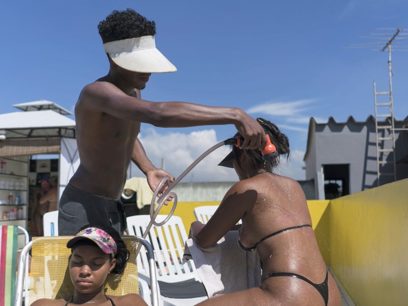 Es ist heiß in Rio. Deshalb sorgt ein Gartenschlauch während der dreistündigen Bräunungssitzung für Abkühlung.