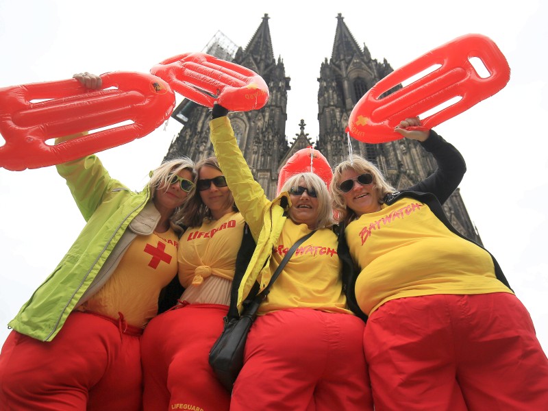 Vor dem Dom posieren diese Karnevalistinnen. Ihre Verkleidung als Rettungsschwimmer ist bei der Wetterlage ja durchaus passend.