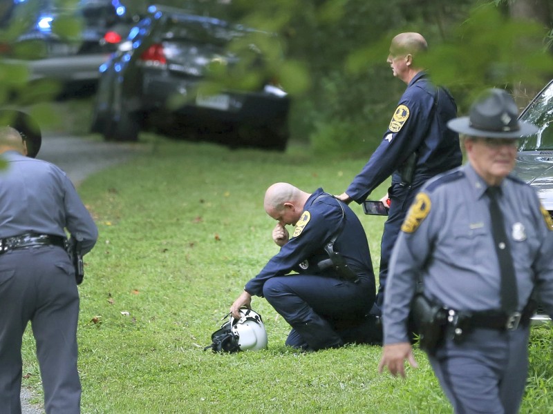 Trauer auch an anderer Stelle: Mitarbeiter der zuständigen Behörden sind in der Nähe der Absturzstelle eines Polizeihubschraubers in Charlottesville im Einsatz. Bei dem Absturz unweit der Kundgebung von Rechtsextremisten kamen beide Besatzungsmitglieder ums Leben.