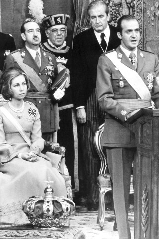 Juan Carlos`große Stunde: Im November 1975 wird er – nach Francos Tod – als König und Staatschef eingesetzt. Das Foto zeigt ihn während seiner Thronrede im Ständeparlament in Madrid, hinter ihm sitzt Königin Sofia. Der Monarch überrascht alle Kritiker, als er entscheidet, die Diktatur zu beenden und den Anstoß zu demokratischen Reformen zu geben.