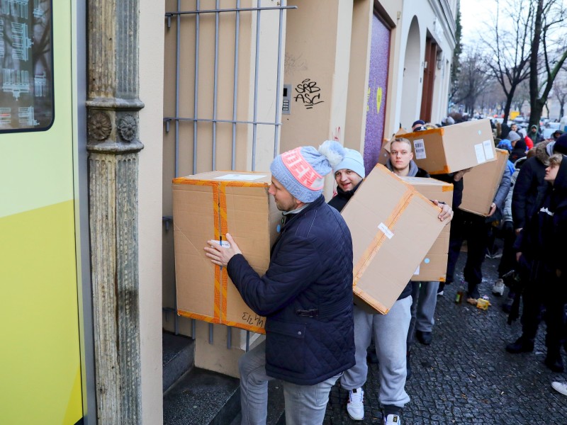 Mitarbeiter des Schuhladens trugen am Dienstagvormittag Kartons mit dem neuen Adidas-Turnschuh vorbei an den wartenden Fans.