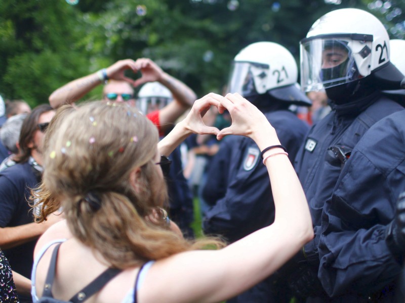 Gewaltfreier Protest: Eine Demonstrantin formte vor Polizisten mit den Händen einen Herz.