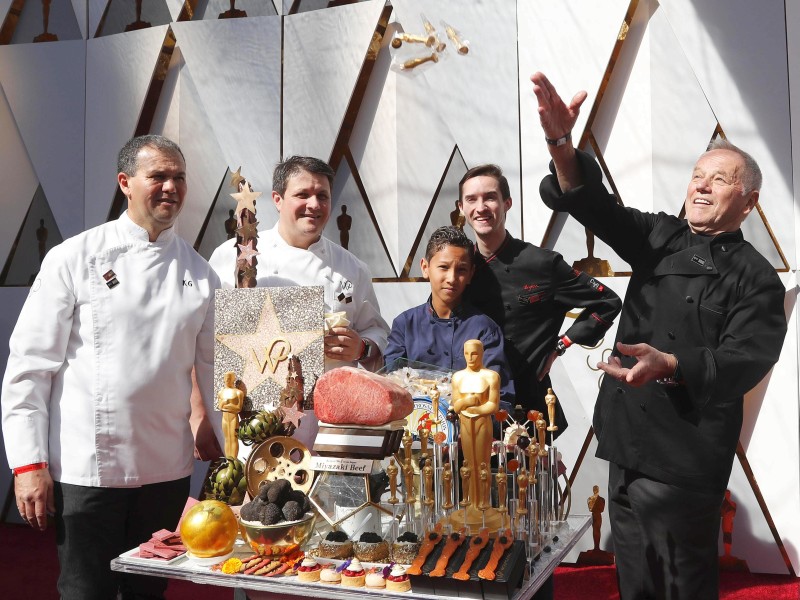 Der Celebrity Koch Wolfgang Puck lässt Süßigkeiten-Oscars auf den Teppich regnen. 