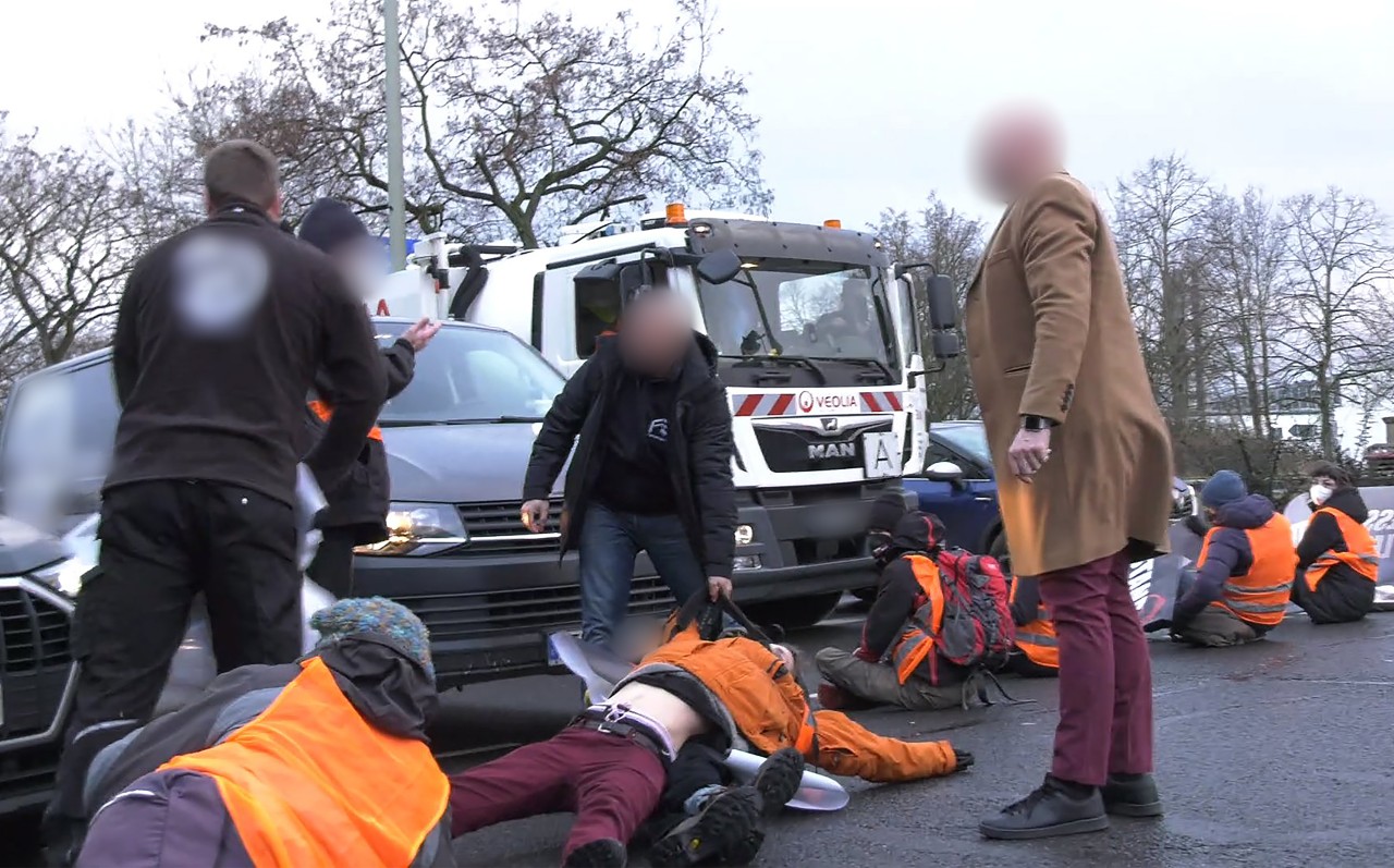 Immer wieder kommt es zu Handgreiflichkeiten von genervten Pendlern gegen die Klimaaktivisten, solange die Polizei noch nicht da ist. 