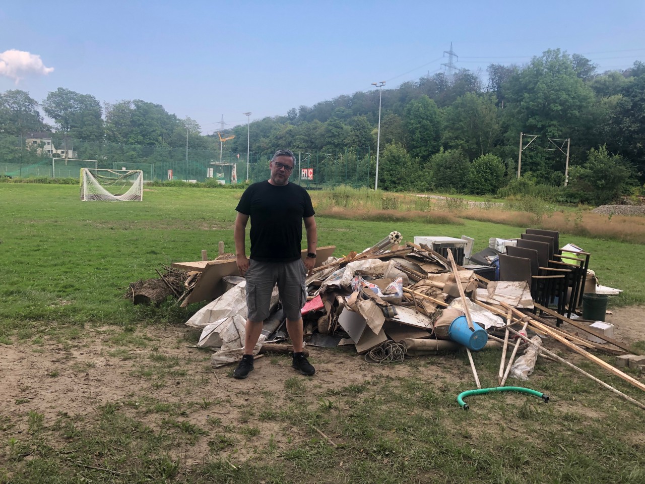 VfL-Vorsitzender Heiko Hommel zwischen den Trümmern, die die Flut hinterlassen hat.