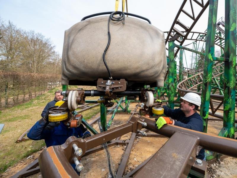 Mitarbeiter setzen im Serengeti-Park einen Achterbahnwagen auf die Schiene. Nach zwei Jahren mit Einschränkungen starten die Freizeitparks Serengeti und Heide Park Soltau am Samstag voll in die Saison.