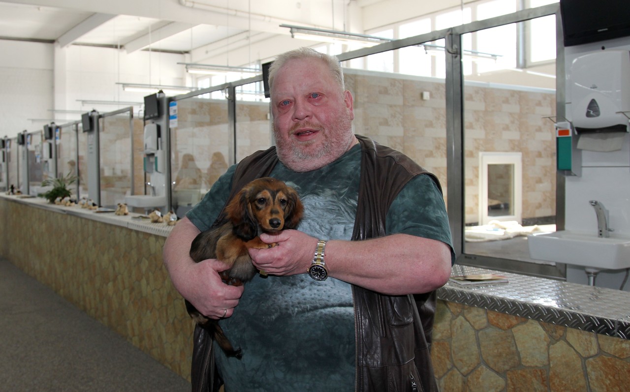 Norbert Zajac, Inhaber des Zoogeschäfts mit einem Langhaardackelwelpen.