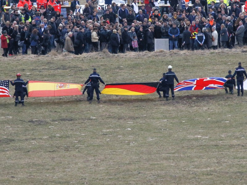 ... Angehörige zu einer Gedenkfeier nach Le Vernet in der Nähe der Absturzstelle. Flaggen repräsentierten einige der Nationalitäten der Opfer.