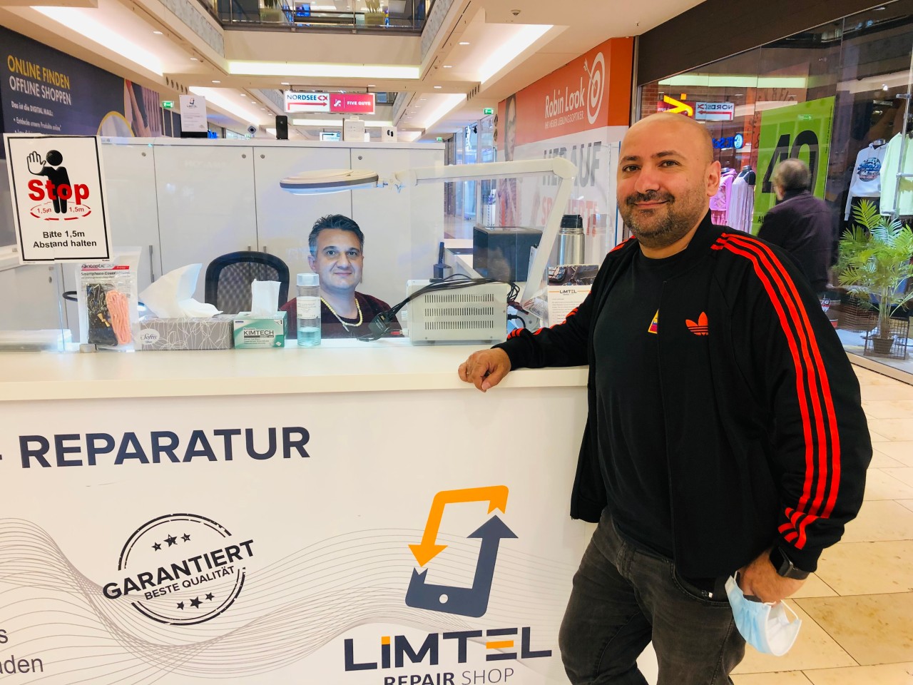 Sinan Elbasi (rechts) aus Bochum an seinem Handy-Reparatur-Stand im Limbecker Platz in Essen.