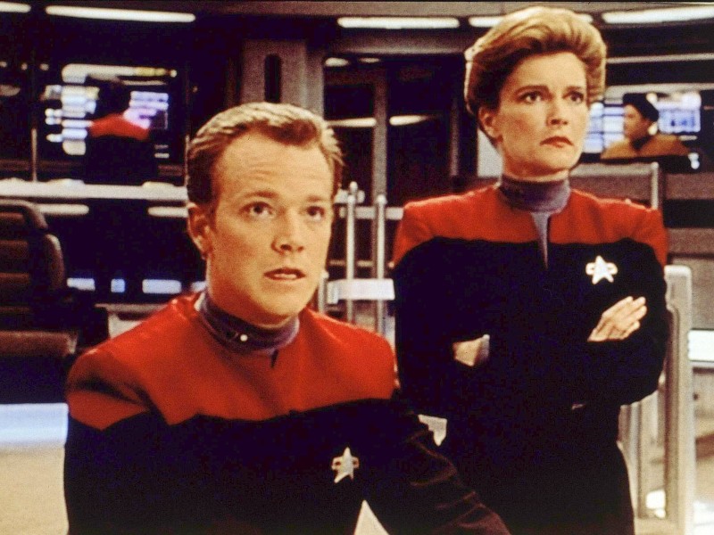 Zum ersten Mal hatte eine Frau das Sagen in einer „Star Trek“-Serie: Captain Kathryn Janeway (gespielt von Kate Mulgrew) und Lieutenant Tom Paris (Robert Duncan McNeill) erlebten ihre Abenteuer wie schon Captain Picard und seine Mannschaft im 24. Jahrhundert.