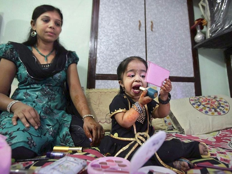 Jyoti Amge zieht den Lippenstift nach, während ihre normalwüchsige Schwester Archna daneben sitzt.