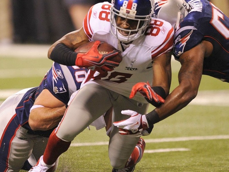 Hakeem Nicks (C) of the New York Giants is brought down during Super Bowl XLVI against the  New England Patriots on February 5, 2012 at Lucas Oil Stadium in Indianapolis, Indiana. AFP PHOTO / TIMOTHY A. CLARY