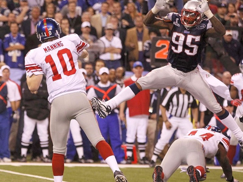 New York Giants quarterback Eli Manning passes over New England Patriots defensive end Mark Anderson in the fourth quarter of the NFL Super Bowl XLVI football game in Indianapolis, Indiana, February 5, 2012. REUTERS/Jeff Haynes (UNITED STATES  - Tags: SPORT FOOTBALL)