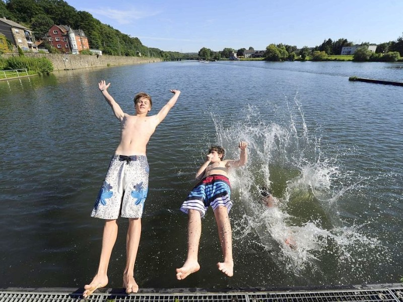 Ausflügler genießen die seit langem ersten schönen Tage des Sommers. Am Ruhrbogen in Bochum-Dahlhausen lassen sich die Jungs rücklings in die Ruhr fallen.