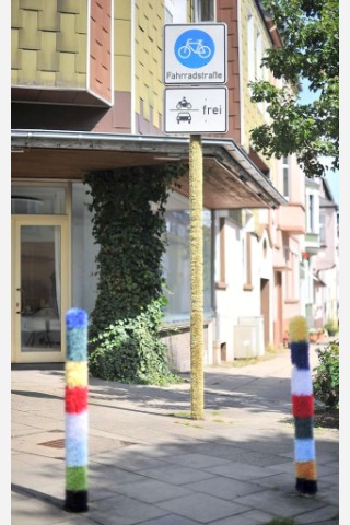 Bestrickte Begrenzungspoller, bunte Baumkleider und ein neuer Strickgarten machen die Emmastraße, Ecke Reginenstraße in Rüttenscheid ein bisschen farbenfroher. Foto: Sebastian Konopka