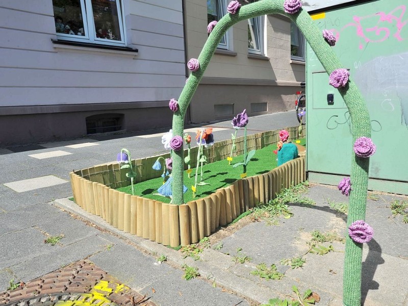 Bestrickte Begrenzungspoller, bunte Baumkleider und ein neuer Strickgarten machen die Emmastraße, Ecke Reginenstraße in Rüttenscheid ein bisschen farbenfroher. Foto: Sebastian Konopka