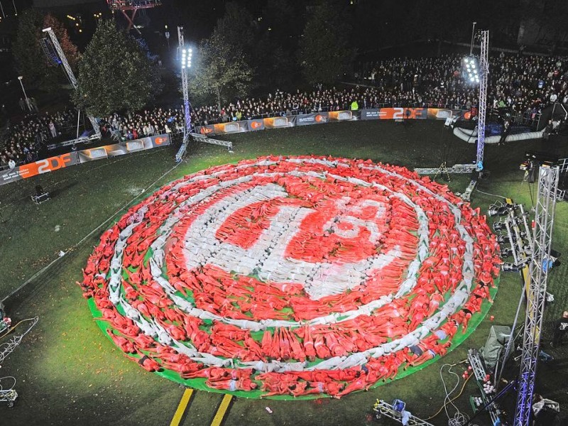 So sieht das aus, wenn Markus Lanz mit NRWs Landeshauptstadtwettet: Wetten, dass sich 500 Düsseldorfer nackt ausziehen, in Rot und Weiß anmalen lassen und sich in Form des Logos der Fortuna Düsseldorf hinlegen?