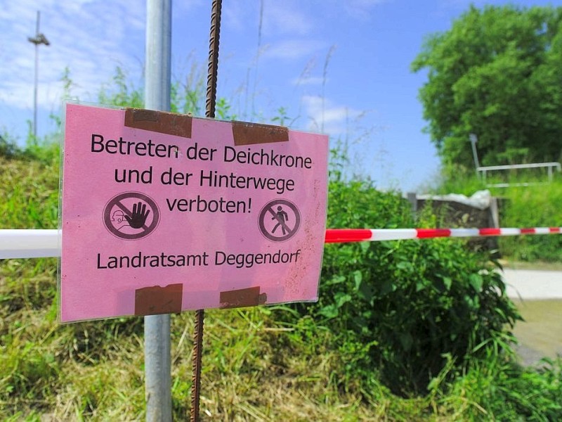 Ein Verbotsschild, das vor dem Betreten der Deichkrone warnt, steht in Metten bei Deggendorf (Bayern) am Rand des Deichs an einer Absperrung.