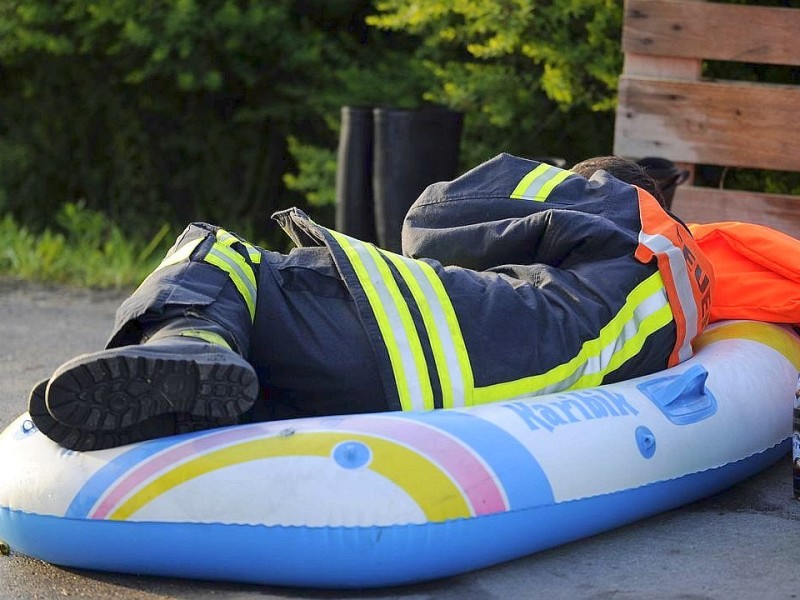 Das Hochwasser kostet die Helfer viel Kraft. Dieser Feuerwehrmann ruht sich kurz auf einem Schlauchboot aus.