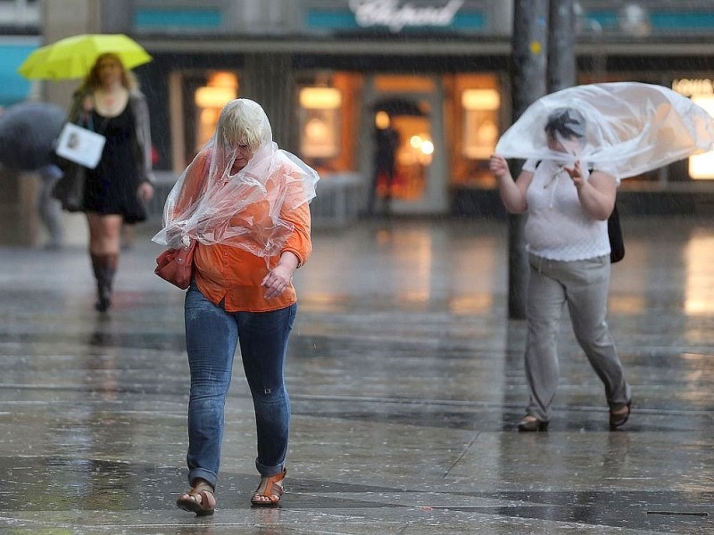 Menschen gehen am in Köln durch den Regen.