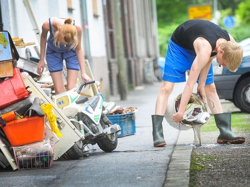 Ab in den Sperrmüll: Am Tag nach dem Unwetter sind Bewohner dabei die Schäden zu sichten und mit den Aufräumungsarbeiten zu beginnen. Wie hier in Witten in der Herbeder Straße hat der Regen deutliche Spuren hinterlassen.