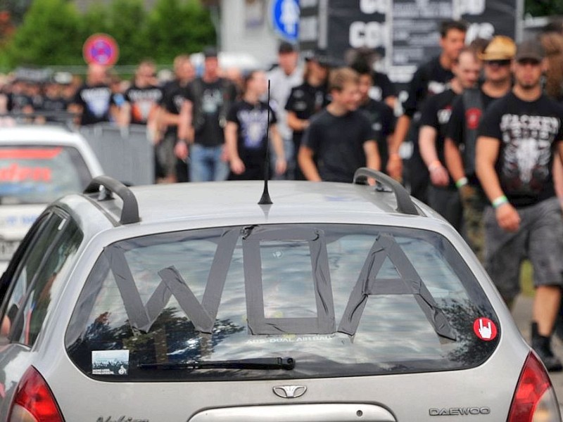 Autos mit dem obligatorsichen WOA-Zeichen im Heckfenster fahren durch Wacken.