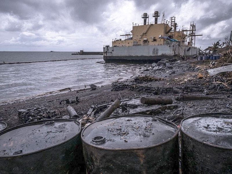 Ölpest in Estancia. Das Generatorschiff Napocor Power Barge 103 wurde durch den Taifun an die Küste geworfen. Das Leck verursachte die Ölkatastrophe. Die Menschen aus dem Stadttteoil sind weitestgehend evakuiert. Die Katastrophenhelferin Lucile von ACF führt Angelika Böhling durch die Unglücksgebiete 28.11.2013 auf der Insel Panay - Phillippinen    Bild: Jakob Studnar