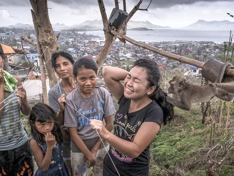 Roxanne-May, Sandora, Emily (Mutter), Christine-Joy und Rejjailyn mit dem Hausaffen. Familie San Miguel in den Trümmern ihres Hauses am Rande der Stadt Estancia. Die Katastrophenhelferin Lucile von ACF führt Angelika Böhling durch die Unglücksgebiete 28.11.2013 auf der Insel Panay - Phillippinen    Bild: Jakob Studnar