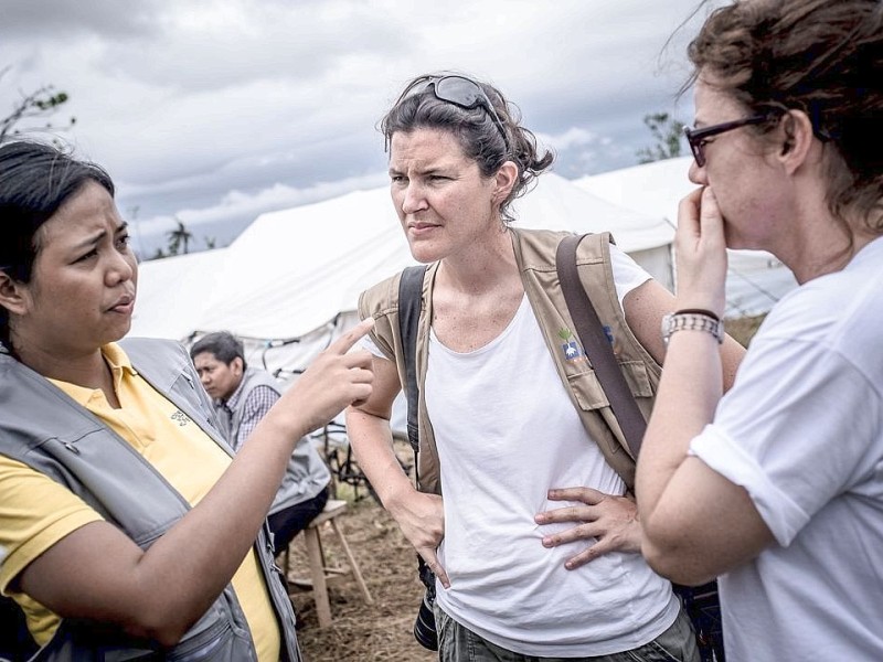 Hilfsorganisationen bauen und organisieren ein Flüchtlingslager / Unterkunft in Estancia. Die Katastrophenhelferin Lucile von ACF führt Angelika Böhling durch die Unglücksgebiete 28.11.2013 auf der Insel Panay - Phillippinen    Bild: Jakob Studnar