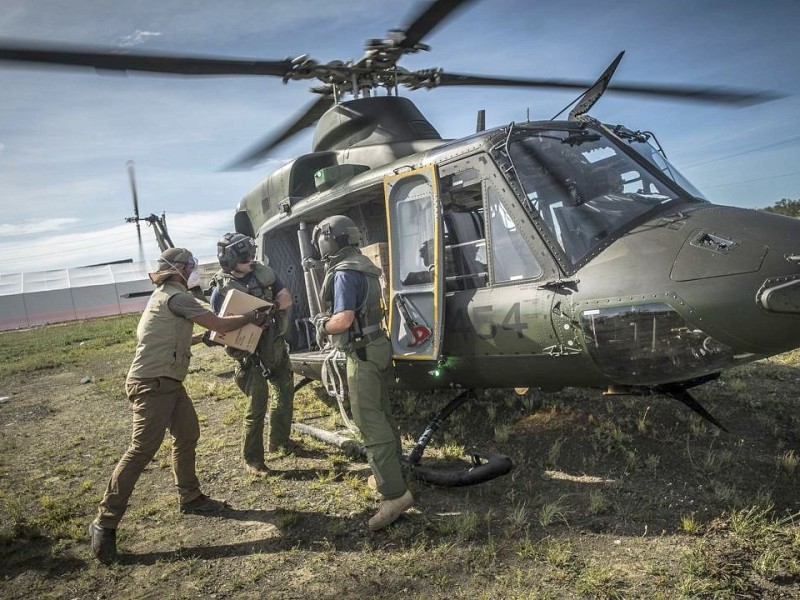 Katastrophenhelfer von ACF, einer Partnerorganisation der Kindernothilfe beladen einen Hubschrauber der Kanadischen Armee mit Nahrungspaketen. Die Notfallnahrung versorgt die Menschen für 14 Tage. Die Kanadische Armee fliegt die Hilfsgüter un unzugängliche Gebiete in den Bergen.  Die Katastrophenhelferin Lucile von ACF führt Angelika Böhling durch die Unglücksgebiete 28.11.2013 auf der Insel Panay - Phillippinen    Bild: Jakob Studnar