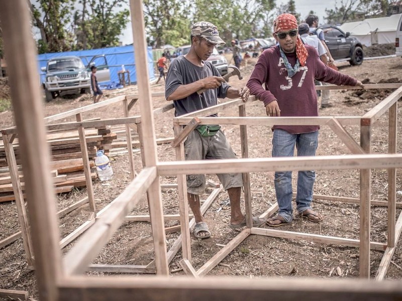 Hilfsorganisationen bauen und organisieren ein Flüchtlingslager / Unterkunft in Estancia. Die Katastrophenhelferin Lucile von ACF führt Angelika Böhling durch die Unglücksgebiete 28.11.2013 auf der Insel Panay - Phillippinen    Bild: Jakob Studnar