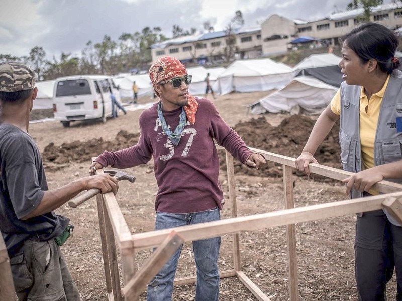 Hilfsorganisationen bauen und organisieren ein Flüchtlingslager / Unterkunft in Estancia. Die Katastrophenhelferin Lucile von ACF führt Angelika Böhling durch die Unglücksgebiete 28.11.2013 auf der Insel Panay - Phillippinen    Bild: Jakob Studnar