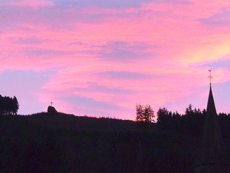 Aus Assinghausen, Richtung Osten, zeigte sich vor dem rötlich leuchtendem Himmel der Strykerstein mit seinem Gipfelkreuz und der Kirchturm der Dorfkirche wie in einem Scherenschnitt, so beschreibt Friedhelm Soer aus Assinghausen sein eingereichtes Leserfoto.