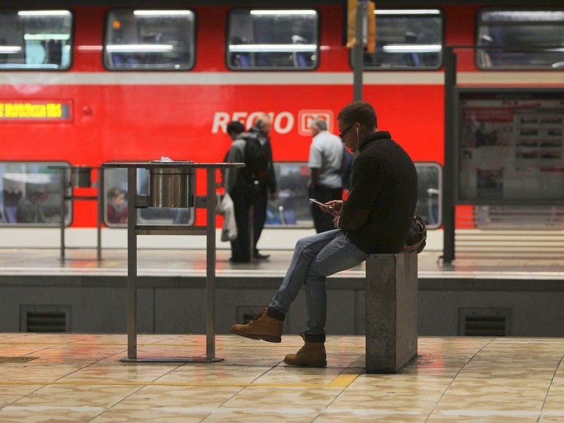 Menschen warten auf ihre Züge.