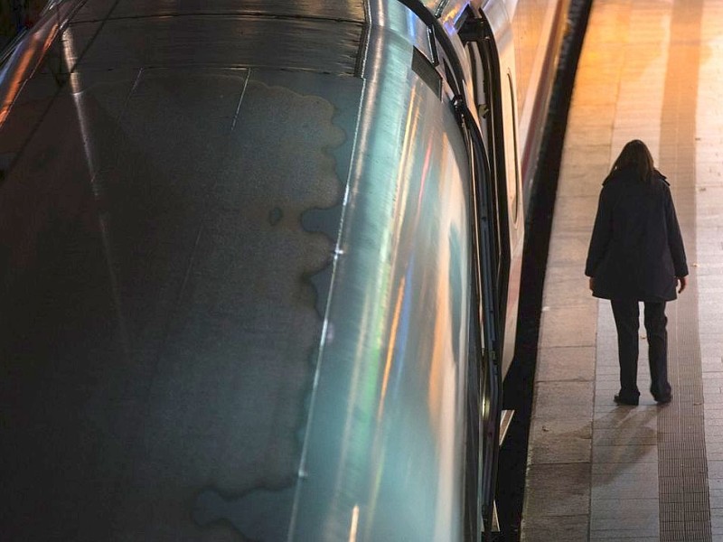 Eine Zugbegleiterin wartet in Hamburg im Hauptbahnhof auf die Abfahrt eines ICE.